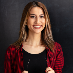 A teacher smiling in front of a blackboard